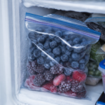 Bag of frozen blueberries and mixed berries in a freezer