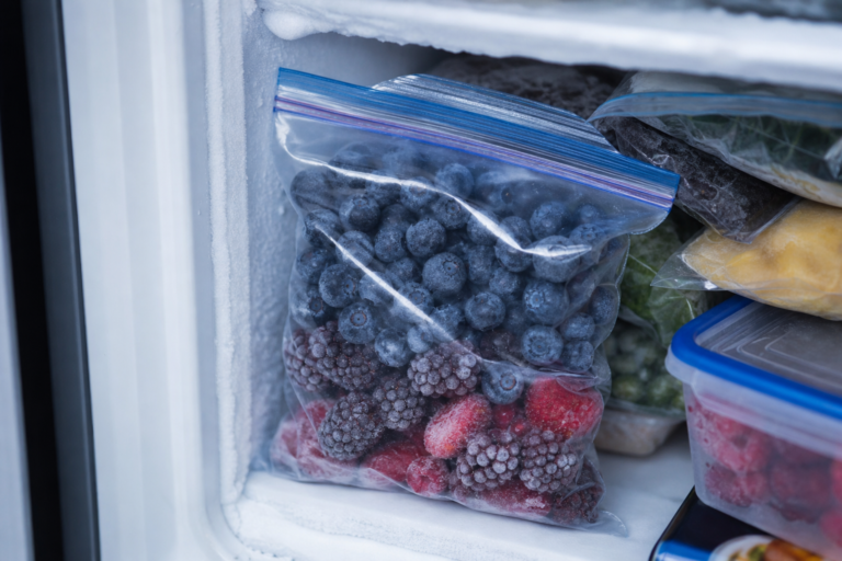 Bag of frozen blueberries and mixed berries in a freezer